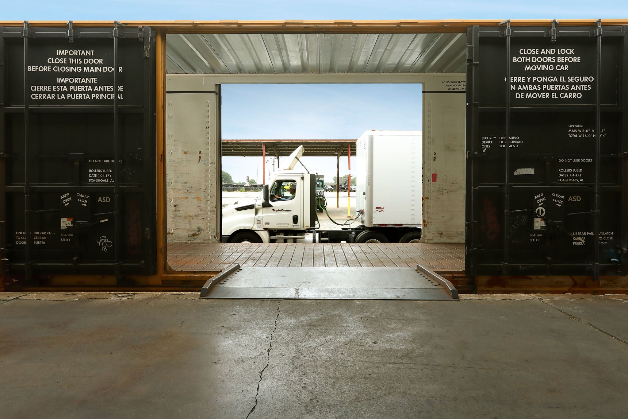 A shot of a delivery truck that is parked behind a Norfolk Southern intermodal shipping container