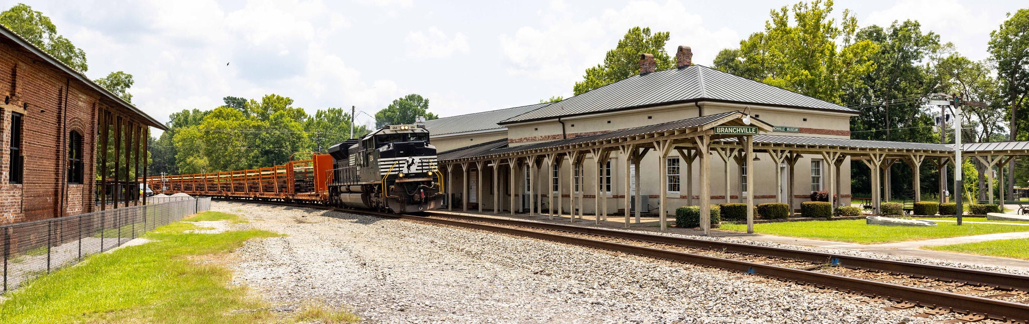 Train moving through train yard community safety Train moving through historic train yard in a way that promotes community safety.