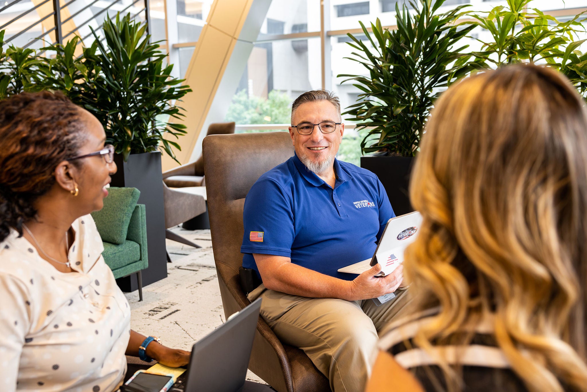 three norfolk southern headquarters employees discussing in common area with plants representing railway jobs