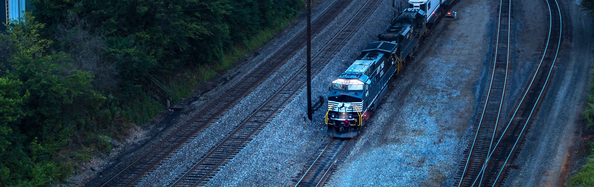 Locomotive carrying chemicals transported by rail near a wooded area