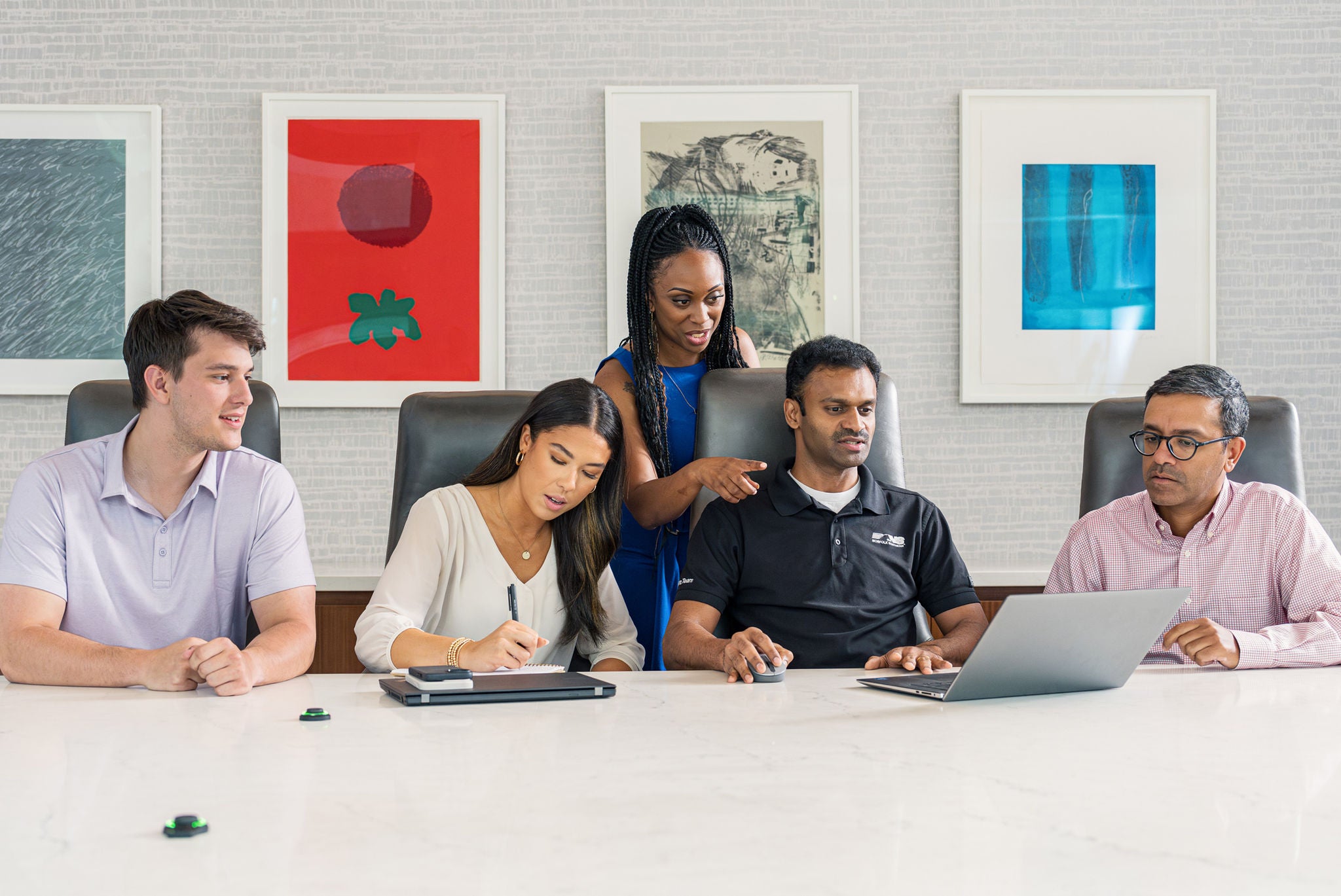 Diverse group of five transportation leaders work together in an office