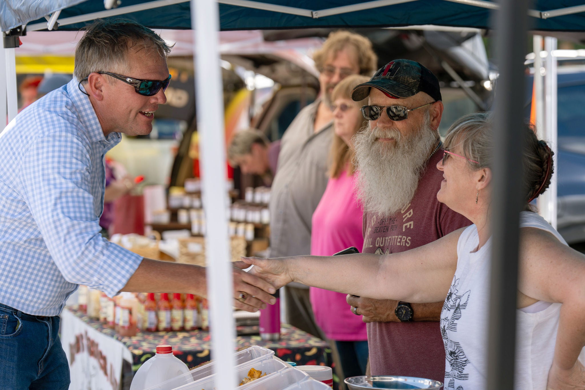 Man shaking hands of two people at a booth showing Norfolk Southern’s customer centric strategy