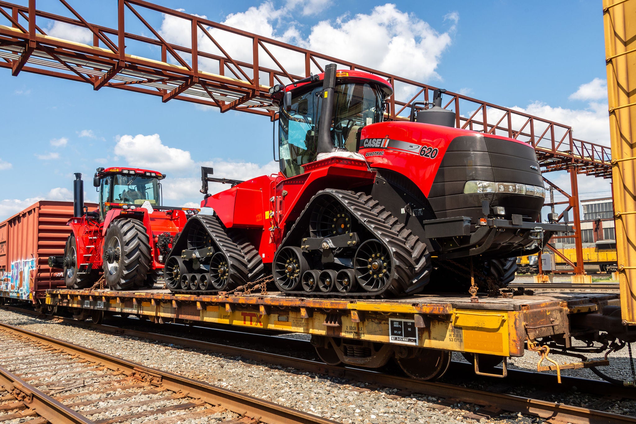 Red Tractor on open train car showing oversize freight shipping options