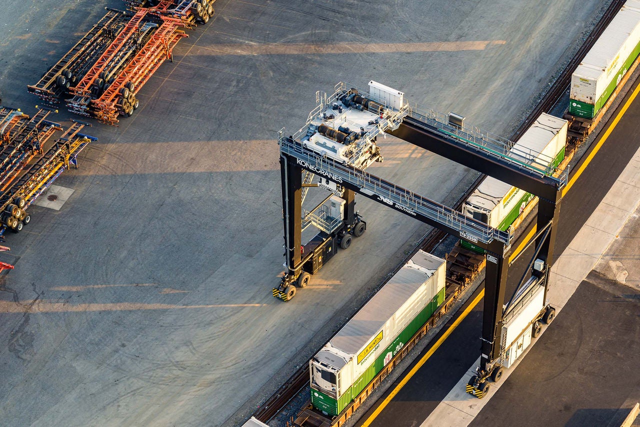 Aerial view of rail transportation company Norfolk southern train cars under a crane