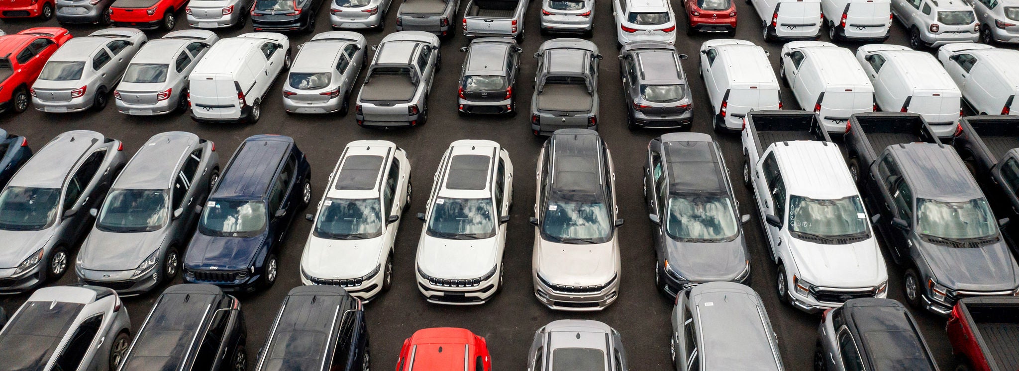 Cars parked on an automobile transport rail aerial An aerial shot of finished vehicles parked on an automobile transport rail.